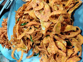 Fried Snake gourd in silver background. A crispy chips