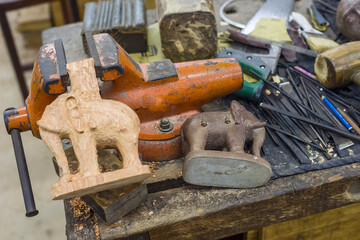 close up of  carved  elephant statue in woodcopying a drawing in Siem Reap