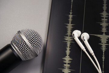 Microphone and headphones. Podcast concept. Sound graph at tablet screen. Closeup flatlay with place for text. Copyspace. Online mobile information. Horizontal banner