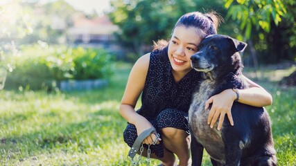 Asian young woman take dog to walk and play together in the backyard garden at home in the morning.Pet love lifestyle concept.