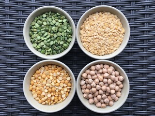 Round bowls with legumes, peas, chickpeas and lentils on a wicker brown background. High quality photo