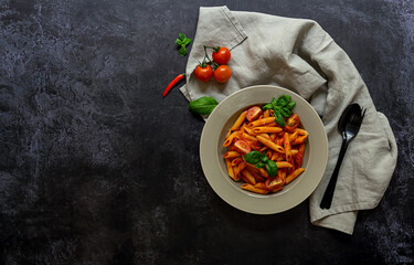Traditional italian arrabbiata penne pasta with tomatoes, red chili peppers, garlic, basil, and cheese. Top view. copy space