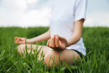 Fototapeta na wymiar The girl is meditating in the field. Close-up photo