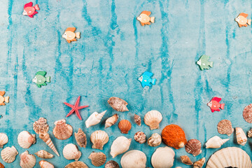 Flat lay of mollusks or shellfish decorated on blue wooden surface. Marine underwater concept textured with blank copy space for summer message.