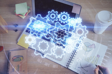 Double exposure of hands and notepad with business icons.