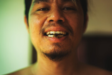 Fototapeta premium Asian young male eating cricket. Eating insect concept