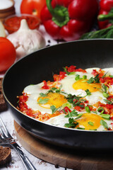 Shakshouka with five cooked eggs on top of tomato sauce in cast iron skillet