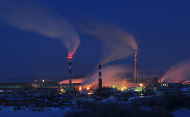 Winter night panorama of the city of Kungur. Working gas boiler rooms connected to urban heating mains.