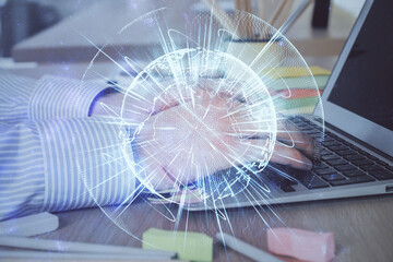 Multi exposure of businessman working on laptop on background. International business hologram in front. Concept of success.