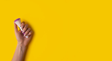 Fototapeta na wymiar Female hands with a beautiful manicure on a yellow background,top view