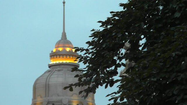 C&uacute;pula en la ciudad con &aacute;rbol meci&eacute;ndose en primer t&eacute;rmino