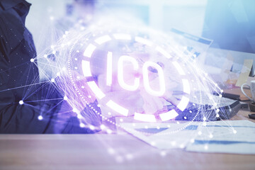 Crypto currency theme hologram with businessman working on computer on background. Concept of...