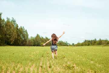 Naklejka na ściany i meble Kid girl jumping on the grass at spring.Summer field, horizon and sky. Happy childhood and freedom.Life Style Outdoors.