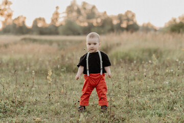little baby boy running on summer grass in field