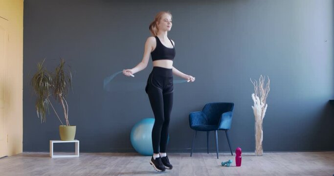 Young sporty woman exercising with skipping rope