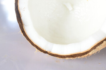 Close up of half of cracked coconut fruit isolated on white background