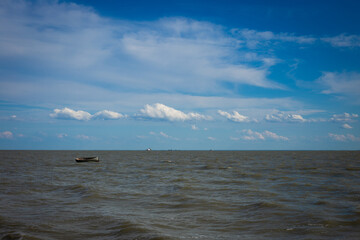a small lonely fishing boat sailing in the middle of the sea