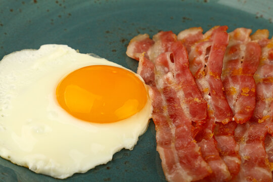 Close Up Sunny Side Egg And Bacon On Blue Plate