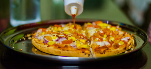 Fresh Homemade cheese pizza, with tomato, onion, corn toppings, with selective focus in lockdown.
