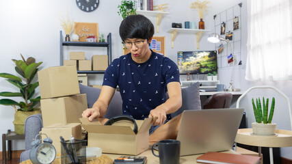 Fototapeta na wymiar small business asian man entrepreneur preparing parcels packing cardboard box for delivery