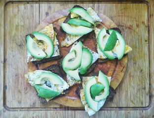 Avocado sandwiches on dark rye bread made with fresh sliced avocados and fried egg