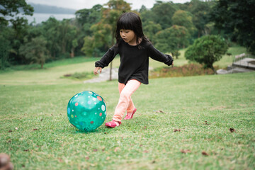 girls run dribbling a ball while playing on the field