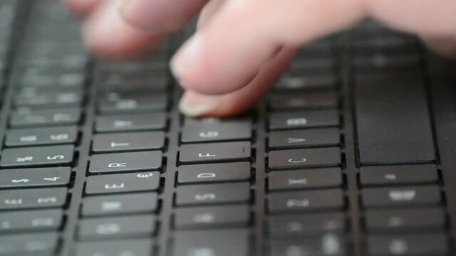 side view of caucasian male hand typing on a laptop computer keyboard. narrow focus. concept for computing technology, office work, home work