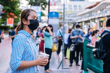 young asian woman with mask  walking in the Bangkok city  