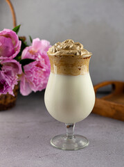 Milk shake. Chocolate and coffee sweet chilled ice-cream drink. Summer drink on the table in a glass goblet on a leg. Bar drinks.