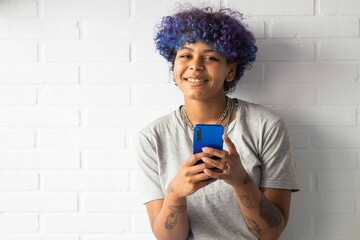 young woman afro american with smartphone on the wall