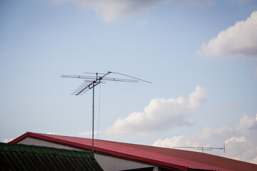 television antenna on roof with blue sky
