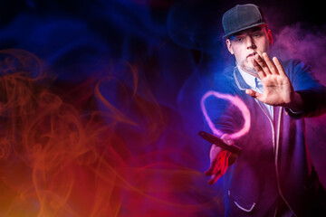 A man in a baseball cap lets out a smoke ring from an e-cigarette. Smoking concept. Fashionable...