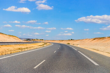 Fototapeta na wymiar empty freeway against a blue sky with clouds