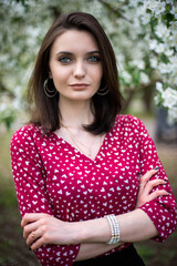 Naklejka premium young, beautiful girl posing in blooming Apple orchards