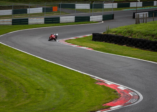 A shot of a red racing bike as it corners fast on a track
