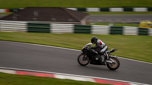 A panning shot of a black racing bike as it circuits a track