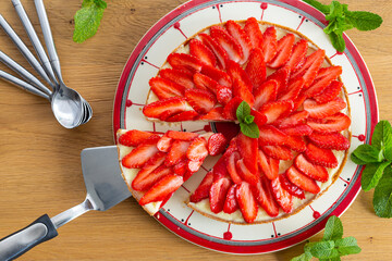 Strawberry pie on a wooden table with mint leaves