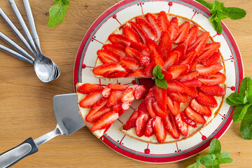 Strawberry pie on a wooden table with mint leaves