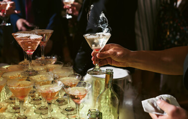 Champagne slide. Pyramid or fountain made of champagne glasses with cherry and steam from dry ice