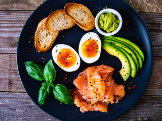 Salmon salad - smoked salmon boiled egg and vegetables on wooden background
