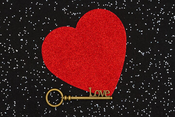 Skeleton key with a red heart on black sparkle felt background