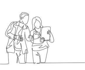One continuous line drawing of young startup members check the work each others using laptop and tablet. Business process teamwork concept. Single line draw design vector illustration
