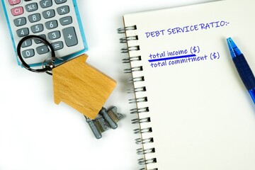 Conceptual image of debt service ratio for home loan repayment appraisal. Wooden key chain...