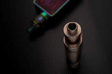 Conceptual of recent uncertainty of health safety of e-cigarette. Isolated close-up of atomizer attached to mouthpiece and battery over