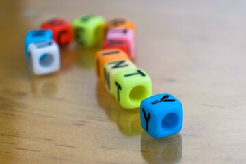 Alphabet beads question mark on wooden reflective table