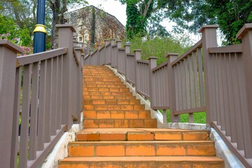 Low angle image of staircase with railing to peak of st paul hill to a famosa, former Portuguese fortress. Focus on selective foreground.