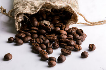 Lots of coffee beans stacked in a beige canvas bag