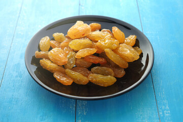 Large yellow raisins on a plate.