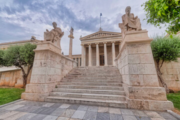 impressive sky over Plato and Socrates the ancient Greek philosophers statues in front of the national academy of Athens, Greece
