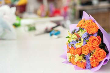 The work of the florist. Flower packaging. Creating a flower bouquet. Roses in a package. Selective focus.
